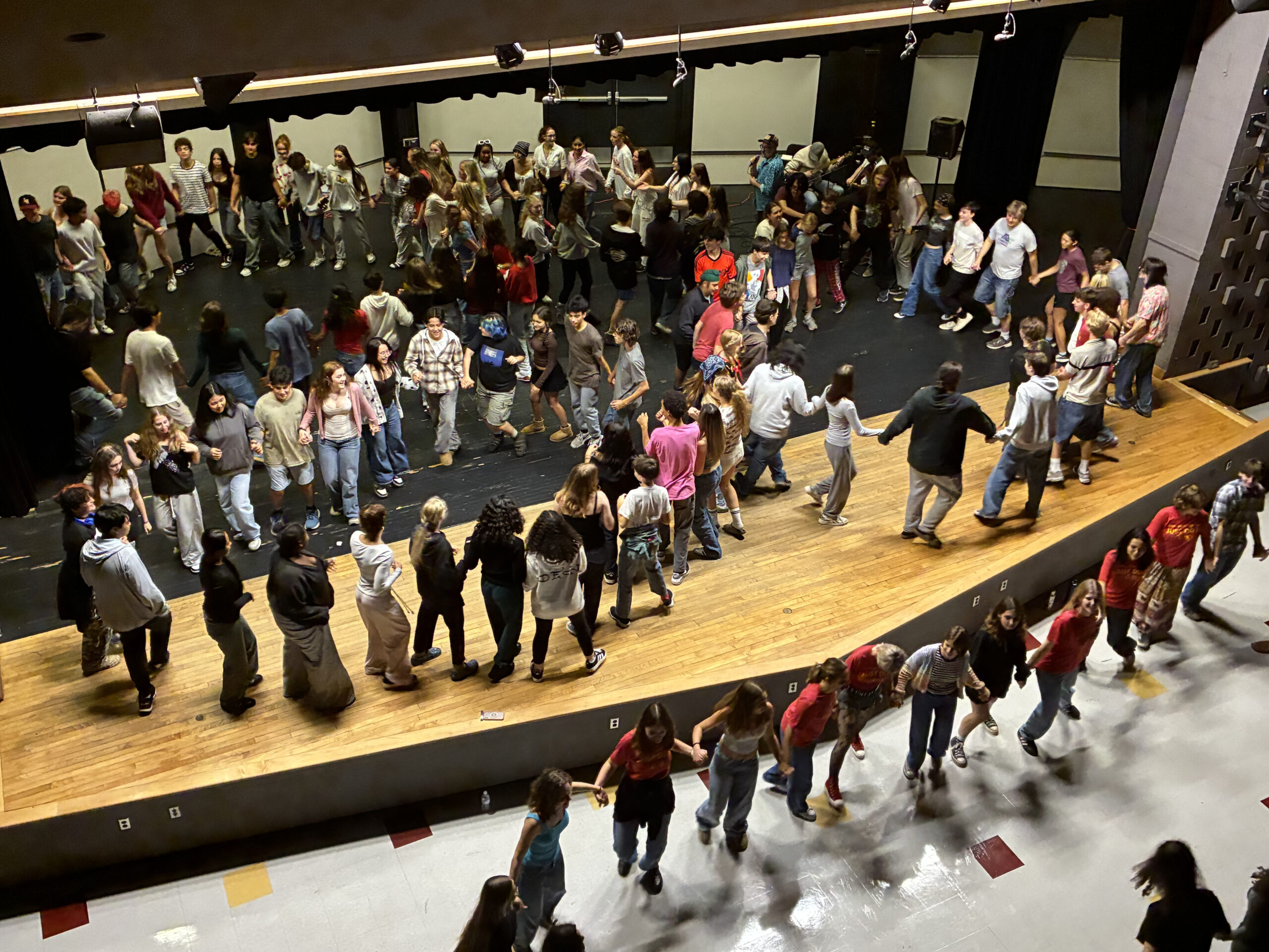 Ithaca High School choir students come together and enjoy a square dance.