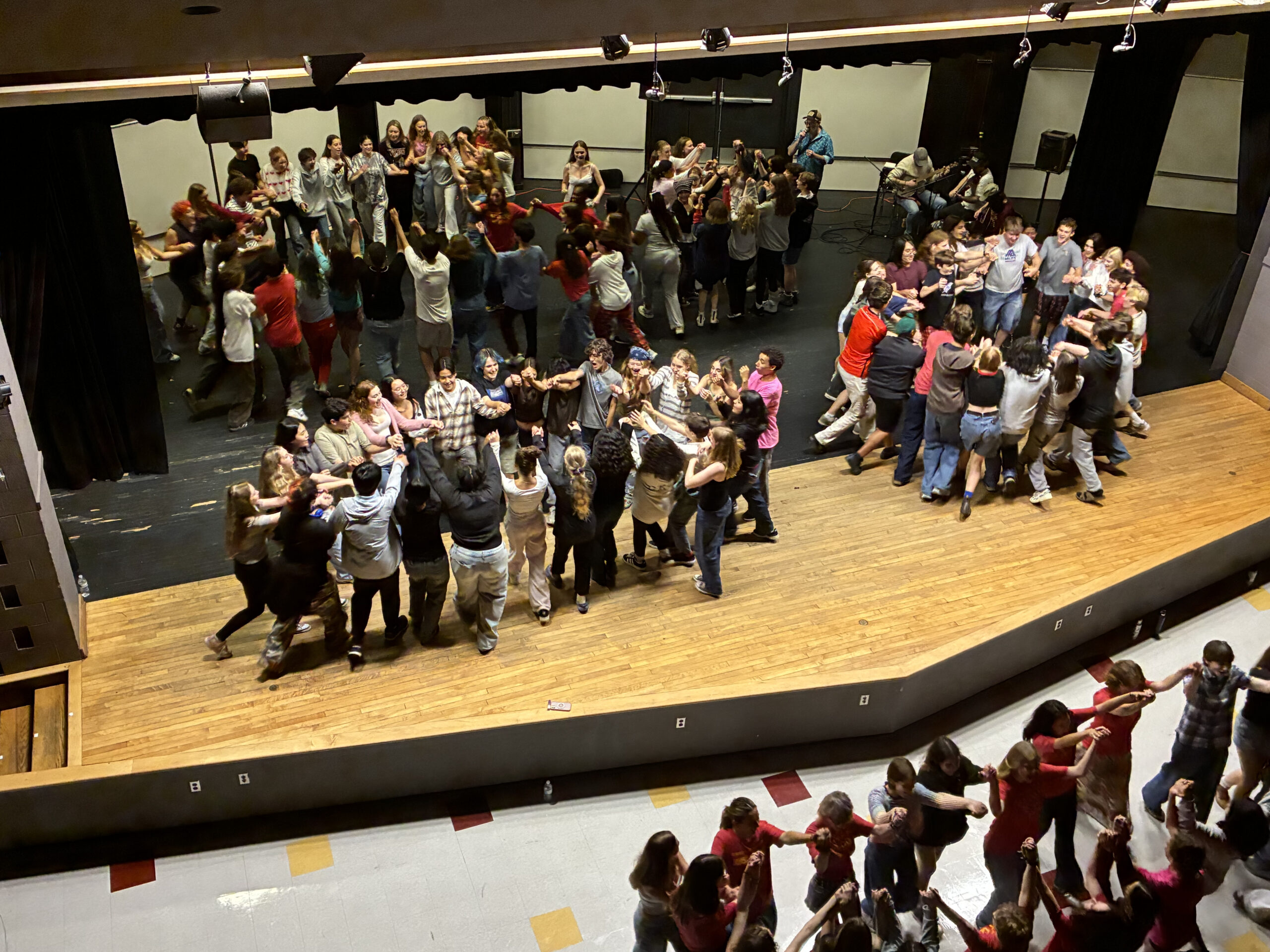 Ithaca High School choir students come together and enjoy a square dance.
