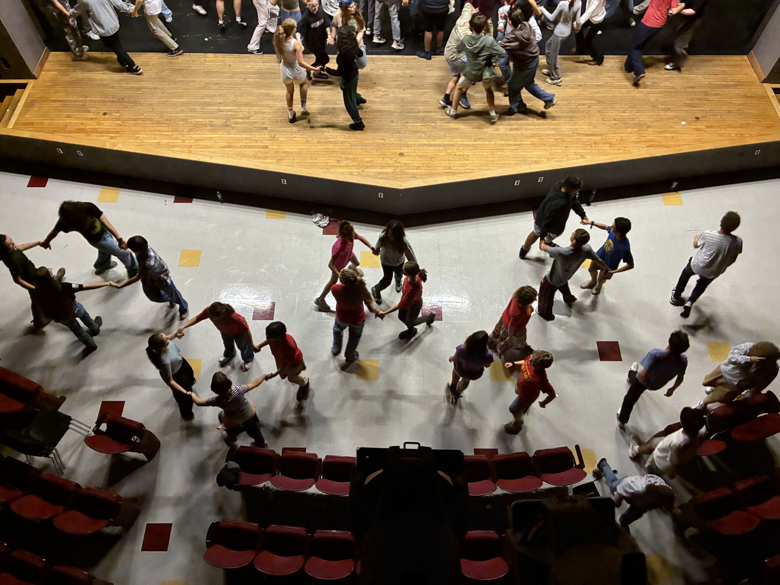 Ithaca High School choir students come together and enjoy a square dance.